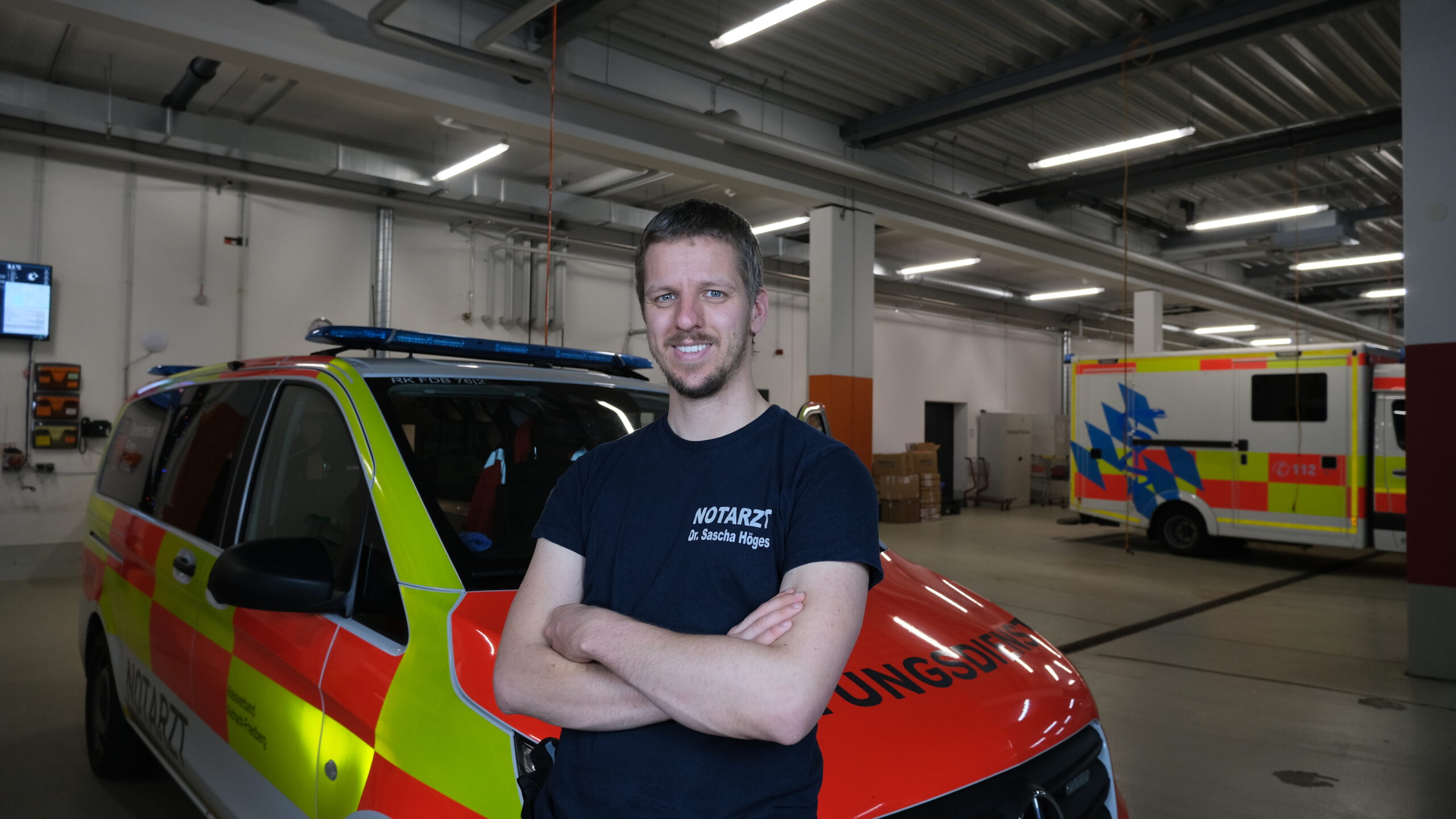 Foto von Sascha Höges im Notarztkleidung vor einem Notarzteinsatzfahrzeug